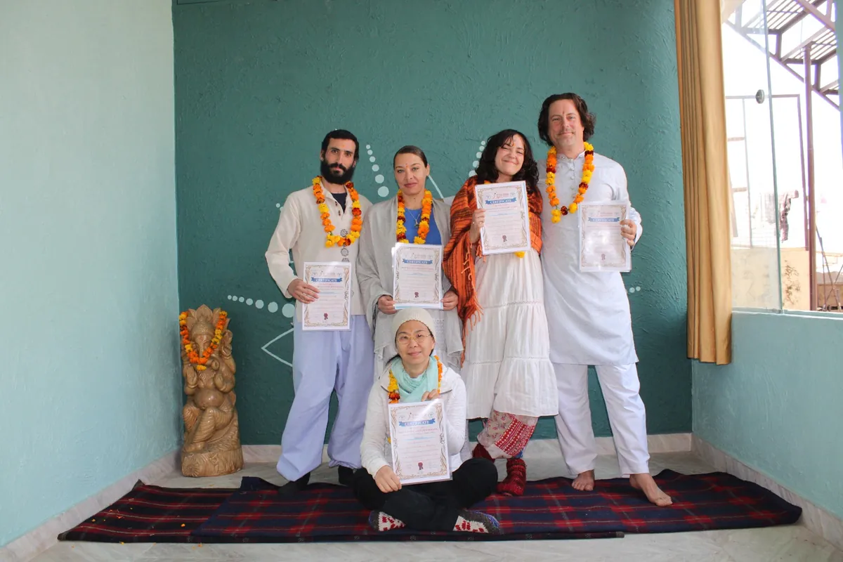Students in white holding Yoga Alliance certificates at Sri Yoga Ashram, Rishikesh