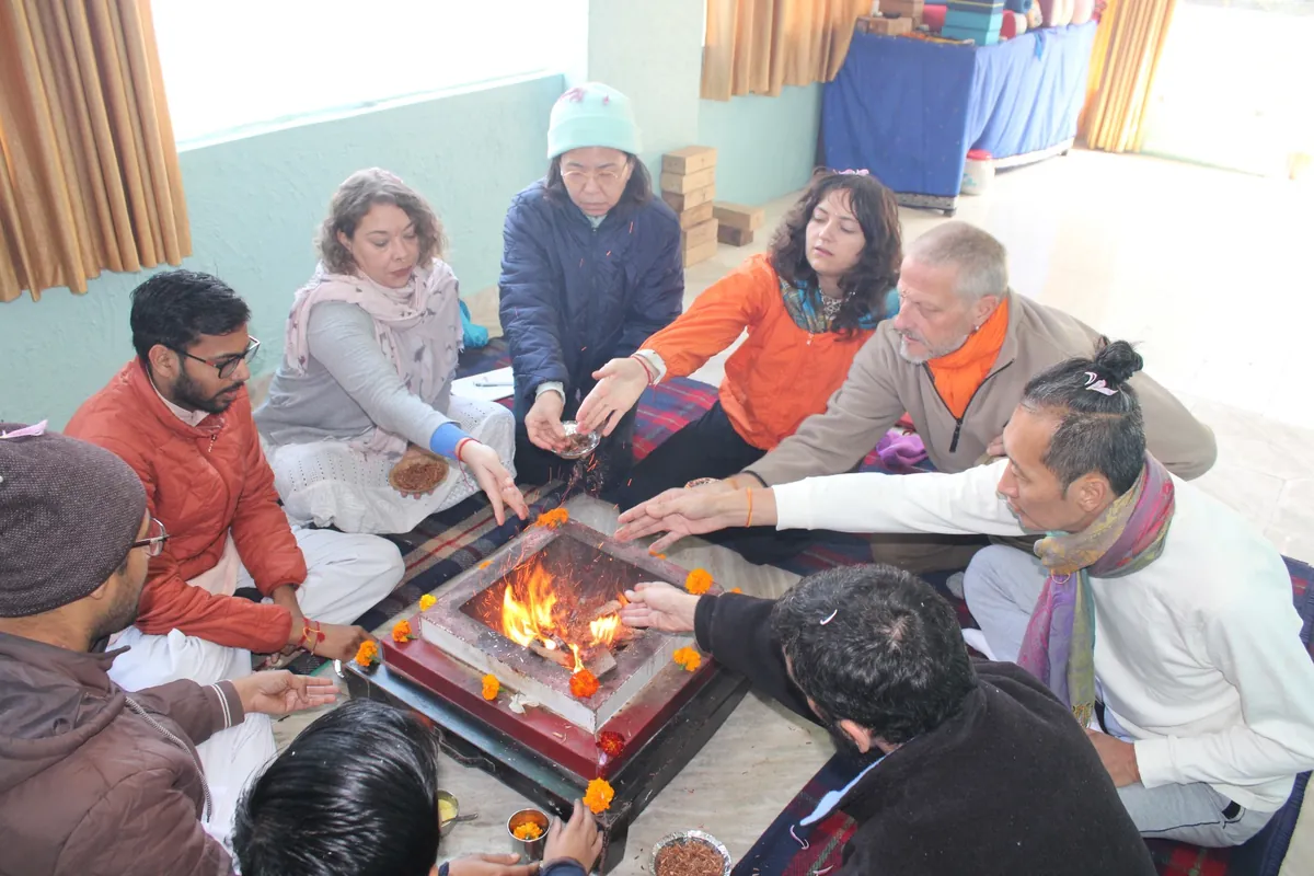 Students gathered around the sacred fire during a havan ceremony at Sri Yoga Ashram, Rishikesh